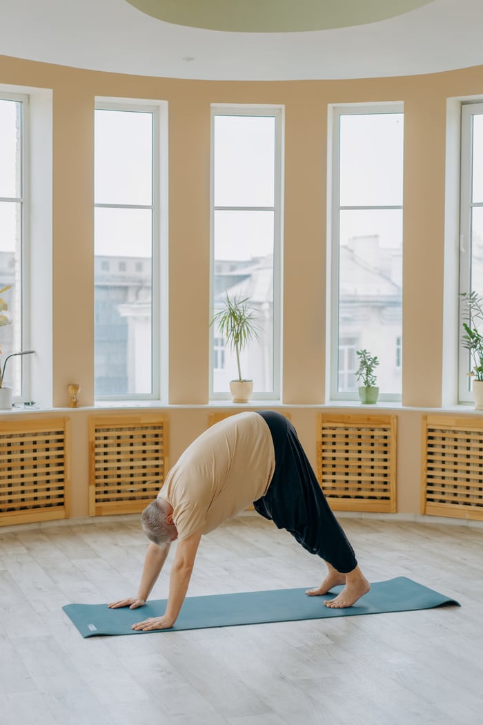 The Art of Drawing Readers In: Your attractive post title goes here Elderly man doing yoga exercise indoors on a mat for fitness and wellness.